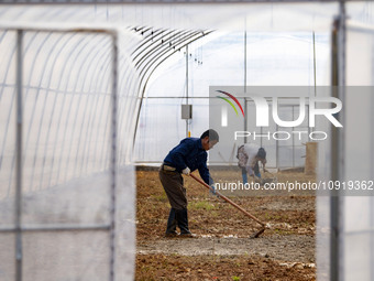 Workers are working at the construction site of a greenhouse for passion fruit cultivation in Congjiang County, Southwest China's Guizhou Pr...