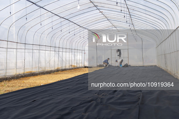 Workers are working at the construction site of a greenhouse for passion fruit cultivation in Congjiang County, Southwest China's Guizhou Pr...