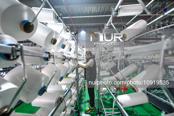 A textile worker is working on a production line at a workshop of a knitting company in Yichun, Jiangxi Province, China, on January 16, 2024...