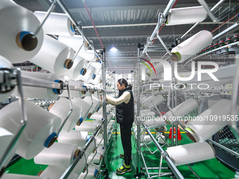 A textile worker is working on a production line at a workshop of a knitting company in Yichun, Jiangxi Province, China, on January 16, 2024...