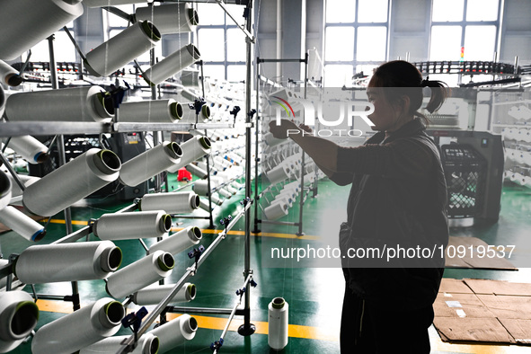 A textile worker is working on a production line at a workshop of a knitting company in Yichun, Jiangxi Province, China, on January 16, 2024...