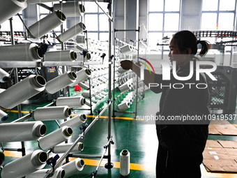 A textile worker is working on a production line at a workshop of a knitting company in Yichun, Jiangxi Province, China, on January 16, 2024...