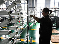 A textile worker is working on a production line at a workshop of a knitting company in Yichun, Jiangxi Province, China, on January 16, 2024...