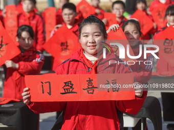 Pupils are showing off the Chinese character ''Fu'' in a Spring Festival couplet at Shangbai Primary School in Deqing County, Huzhou City, Z...