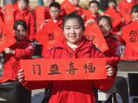 Pupils are showing off the Chinese character ''Fu'' in a Spring Festival couplet at Shangbai Primary School in Deqing County, Huzhou City, Z...