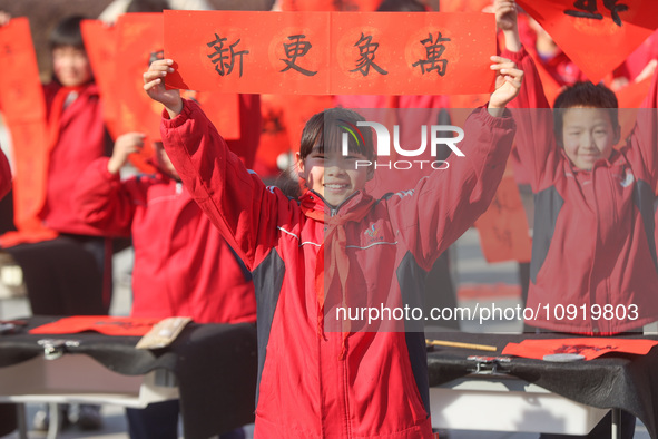 Pupils are showing off the Chinese character ''Fu'' in a Spring Festival couplet at Shangbai Primary School in Deqing County, Huzhou City, Z...