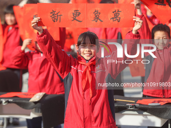 Pupils are showing off the Chinese character ''Fu'' in a Spring Festival couplet at Shangbai Primary School in Deqing County, Huzhou City, Z...