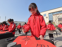 A primary school student is writing a Chinese Spring Festival couplet ''Fu'' at Shangbai Primary School in Deqing County, Huzhou, China, on...