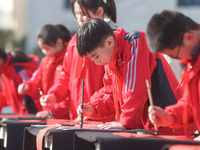 A primary school student is writing a Chinese Spring Festival couplet ''Fu'' at Shangbai Primary School in Deqing County, Huzhou, China, on...