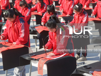 A primary school student is writing a Chinese Spring Festival couplet ''Fu'' at Shangbai Primary School in Deqing County, Huzhou, China, on...