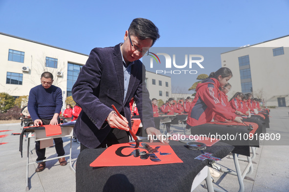 Teachers are writing a Chinese Spring Festival couplet ''Fu'' at Shangbai Primary School in Deqing County, Huzhou, China, on January 17, 202...