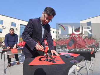 Teachers are writing a Chinese Spring Festival couplet ''Fu'' at Shangbai Primary School in Deqing County, Huzhou, China, on January 17, 202...