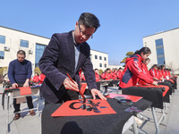 Teachers are writing a Chinese Spring Festival couplet ''Fu'' at Shangbai Primary School in Deqing County, Huzhou, China, on January 17, 202...