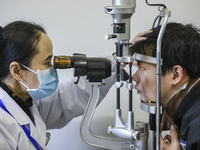 A medical worker is checking the eyes of a young applicant in Huai'an, China, on January 19, 2024. (