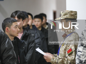 A cadre is checking the information of young applicants in Huai'an, China, on January 19, 2024. (