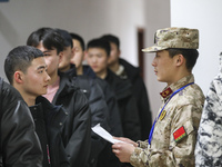 A cadre is checking the information of young applicants in Huai'an, China, on January 19, 2024. (