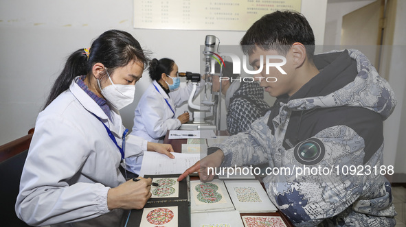 A medical worker is checking the eyesight of a young applicant in Huai'an, Jiangsu Province, China, on January 19, 2024. 