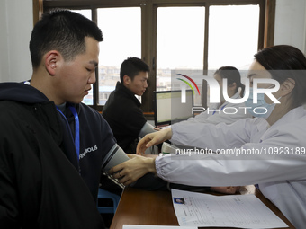 A medical worker is measuring the blood pressure of a young applicant in Huai'an, Jiangsu Province, China, on January 19, 2024. (