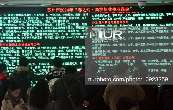 Job seekers are looking for positions at a job fair for 2024 college graduates in Suzhou, Jiangsu Province, China, on January 19, 2024. 