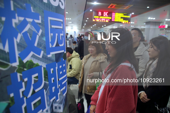 Job seekers are looking for positions at a job fair for 2024 college graduates in Suzhou, Jiangsu Province, China, on January 19, 2024. 