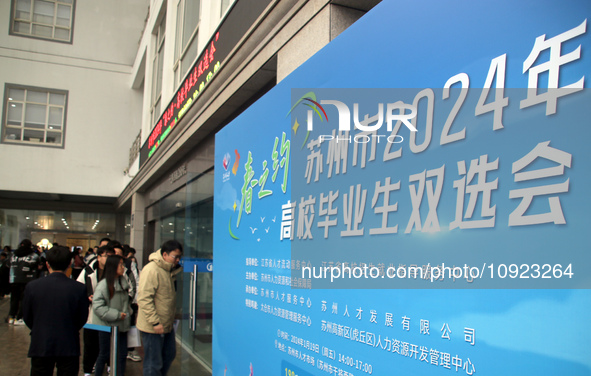 Job seekers are looking for positions at a job fair for 2024 college graduates in Suzhou, Jiangsu Province, China, on January 19, 2024. 