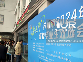 Job seekers are looking for positions at a job fair for 2024 college graduates in Suzhou, Jiangsu Province, China, on January 19, 2024. (