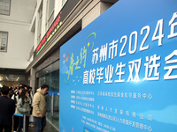 Job seekers are looking for positions at a job fair for 2024 college graduates in Suzhou, Jiangsu Province, China, on January 19, 2024. (