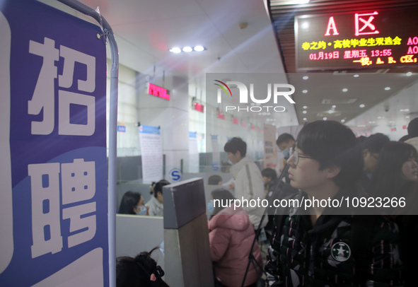 Job seekers are looking for positions at a job fair for 2024 college graduates in Suzhou, Jiangsu Province, China, on January 19, 2024. 