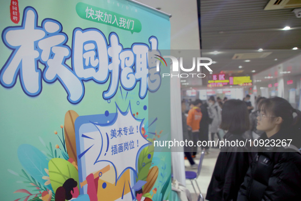 Job seekers are looking for positions at a job fair for 2024 college graduates in Suzhou, Jiangsu Province, China, on January 19, 2024. 