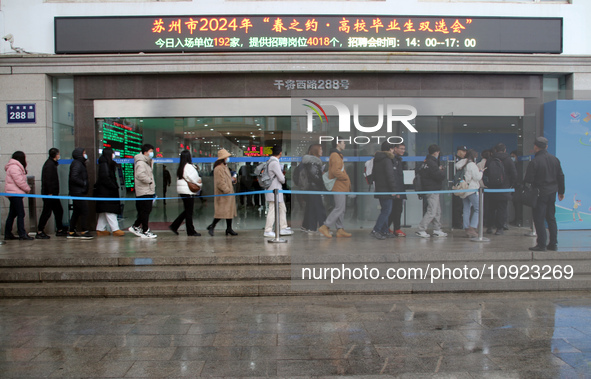 Job seekers are looking for positions at a job fair for 2024 college graduates in Suzhou, Jiangsu Province, China, on January 19, 2024. 