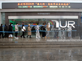 Job seekers are looking for positions at a job fair for 2024 college graduates in Suzhou, Jiangsu Province, China, on January 19, 2024. (