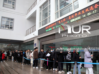 Job seekers are looking for positions at a job fair for 2024 college graduates in Suzhou, Jiangsu Province, China, on January 19, 2024. (