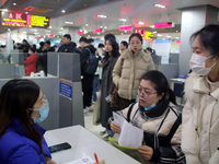 Job seekers are looking for positions at a job fair for 2024 college graduates in Suzhou, Jiangsu Province, China, on January 19, 2024. (