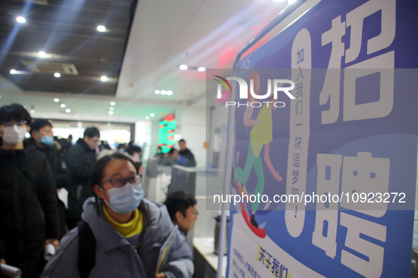 Job seekers are looking for positions at a job fair for 2024 college graduates in Suzhou, Jiangsu Province, China, on January 19, 2024. 