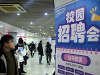 Job seekers are looking for positions at a job fair for 2024 college graduates in Suzhou, Jiangsu Province, China, on January 19, 2024. (