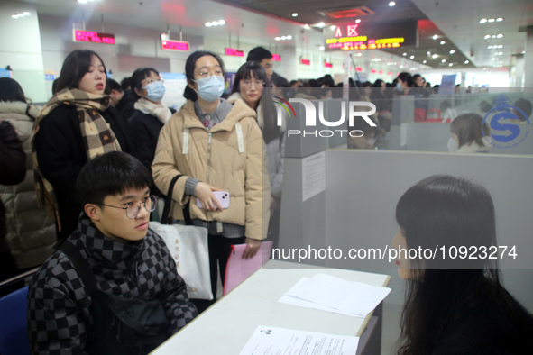 Job seekers are looking for positions at a job fair for 2024 college graduates in Suzhou, Jiangsu Province, China, on January 19, 2024. 