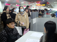 Job seekers are looking for positions at a job fair for 2024 college graduates in Suzhou, Jiangsu Province, China, on January 19, 2024. (