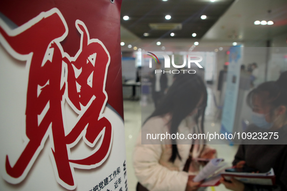 Job seekers are looking for positions at a job fair for 2024 college graduates in Suzhou, Jiangsu Province, China, on January 19, 2024. 