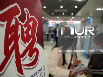 Job seekers are looking for positions at a job fair for 2024 college graduates in Suzhou, Jiangsu Province, China, on January 19, 2024. (