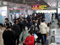 Job seekers are looking for positions at a job fair for 2024 college graduates in Suzhou, Jiangsu Province, China, on January 19, 2024. (