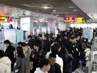 Job seekers are looking for positions at a job fair for 2024 college graduates in Suzhou, Jiangsu Province, China, on January 19, 2024. (