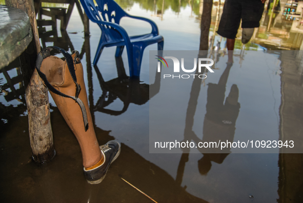 A prosthetic leg is lying beside a pillar in the Sicanang settlement, which is experiencing tidal flooding in Medan, North Sumatra Province,...