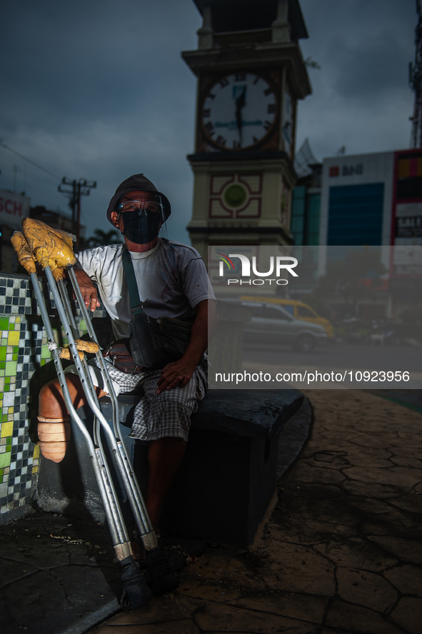 Tukino, 56, a resident of a leprosy settlement, is standing with a prosthetic leg at a traffic intersection in Medan, North Sumatra Province...