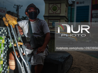 Tukino, 56, a resident of a leprosy settlement, is standing with a prosthetic leg at a traffic intersection in Medan, North Sumatra Province...