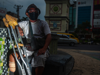 Tukino, 56, a resident of a leprosy settlement, is standing with a prosthetic leg at a traffic intersection in Medan, North Sumatra Province...