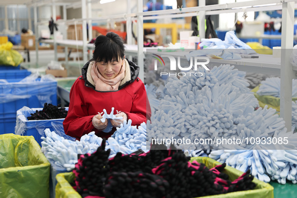 A worker is producing protective equipment for export in Lianyungang, China, on January 22, 2024. 