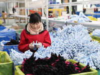 A worker is producing protective equipment for export in Lianyungang, China, on January 22, 2024. (