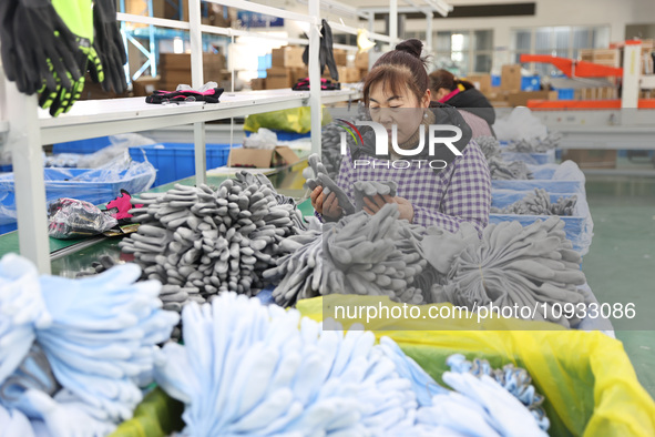 A worker is producing protective equipment for export in Lianyungang, China, on January 22, 2024. 