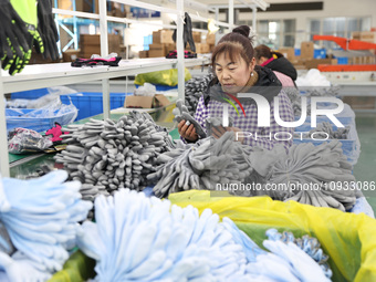 A worker is producing protective equipment for export in Lianyungang, China, on January 22, 2024. (