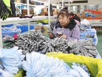 A worker is producing protective equipment for export in Lianyungang, China, on January 22, 2024. (